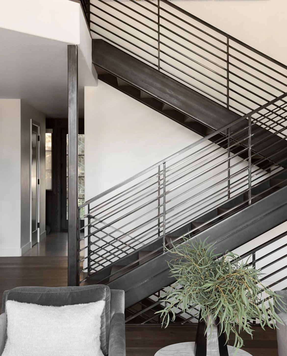 Amaro 8-inch wide plank American walnut flooring beside a blackened steel staircase — Bella House project