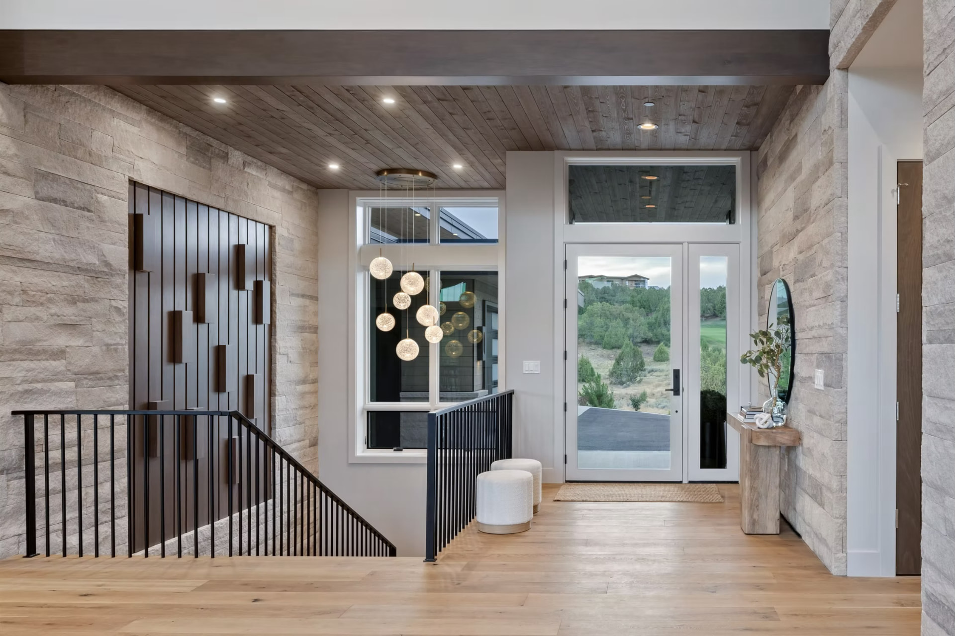 Lune wide plank European oak flooring in the entry hall beside a carved wood relief wall — Red Mountain project